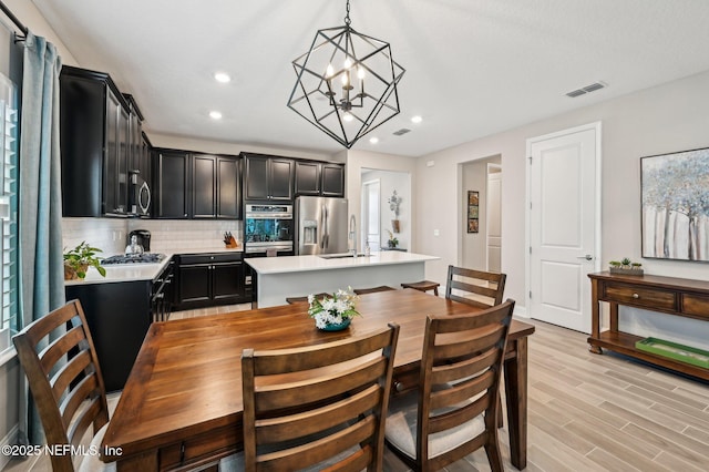 dining room with light wood-style flooring, visible vents, and recessed lighting