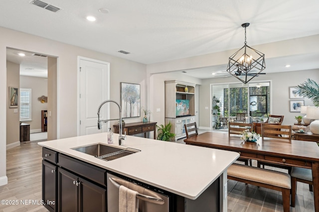 kitchen featuring a sink, visible vents, light wood-style floors, light countertops, and stainless steel dishwasher