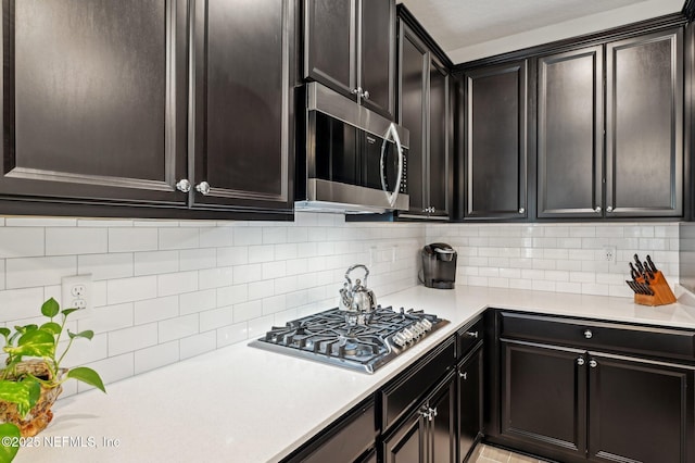 kitchen featuring light countertops, appliances with stainless steel finishes, and backsplash