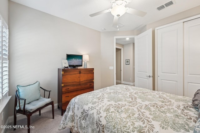 carpeted bedroom featuring a closet, visible vents, ceiling fan, and baseboards