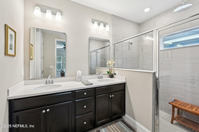 full bathroom featuring double vanity, a stall shower, and a sink