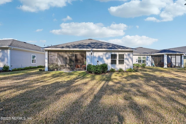 back of property featuring a sunroom and a lawn