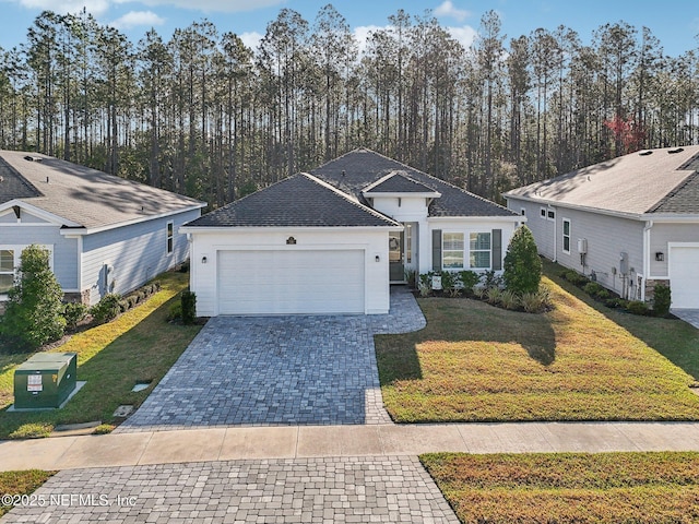 ranch-style home with a garage, decorative driveway, and a front yard