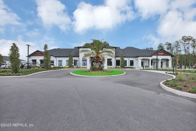 view of building exterior with curved driveway and a residential view