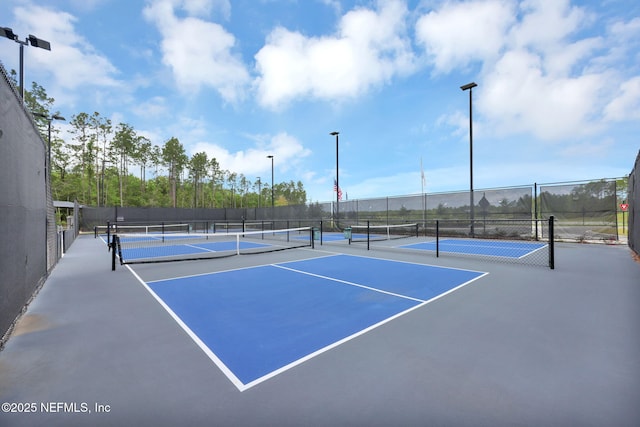 view of tennis court featuring fence
