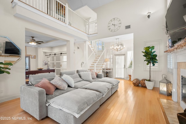 living area with a barn door, a fireplace, wood finished floors, and visible vents