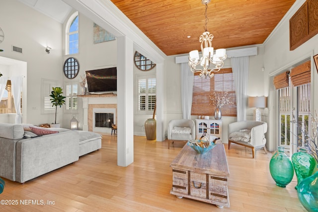 interior space featuring a notable chandelier, wood ceiling, light wood-style flooring, and crown molding