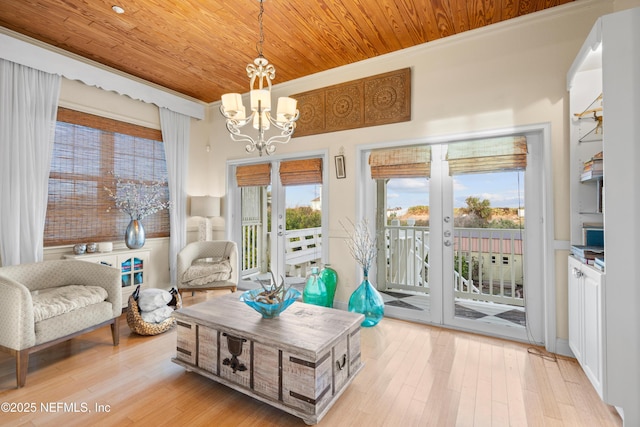 living area with a chandelier, wooden ceiling, light wood-style flooring, french doors, and crown molding