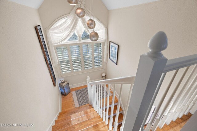 stairway featuring baseboards and wood finished floors