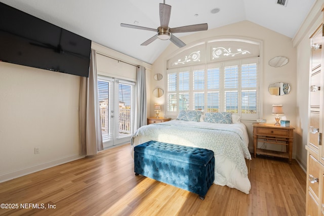 bedroom featuring access to exterior, lofted ceiling, baseboards, and wood finished floors