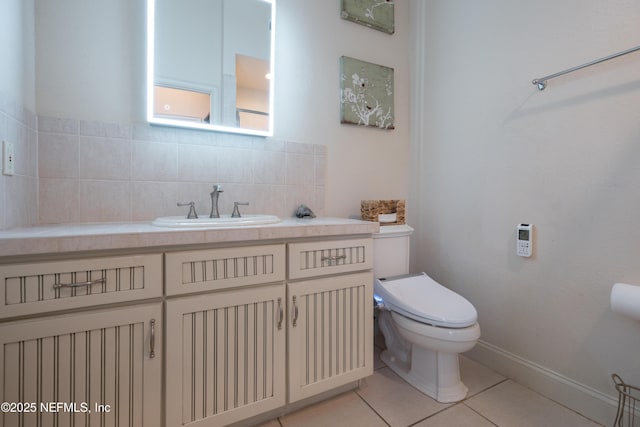 half bathroom with backsplash, toilet, vanity, baseboards, and tile patterned floors