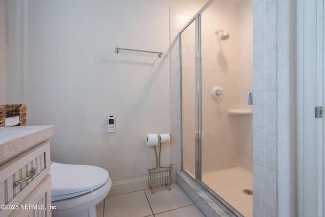 bathroom featuring toilet, a shower stall, vanity, and tile patterned floors