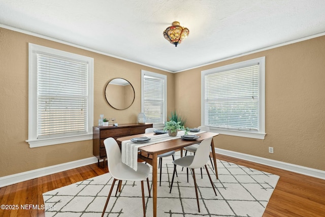 dining space with a wealth of natural light, baseboards, and wood finished floors