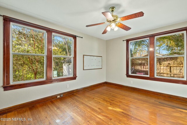 unfurnished room featuring a ceiling fan, baseboards, and wood finished floors