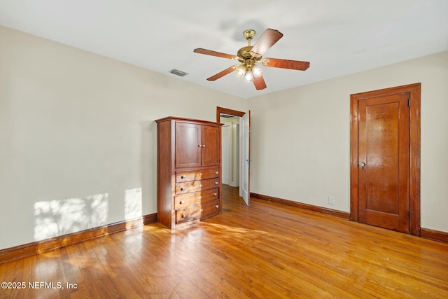 unfurnished bedroom featuring baseboards, visible vents, ceiling fan, and light wood finished floors