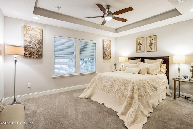 bedroom featuring ceiling fan, carpet, baseboards, and a raised ceiling