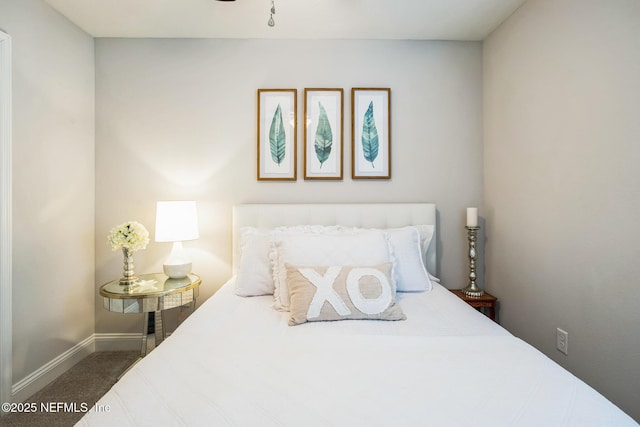 bedroom with baseboards and dark carpet