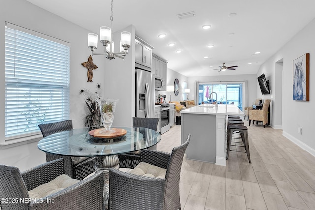 dining area with ceiling fan with notable chandelier, wood tiled floor, baseboards, and recessed lighting