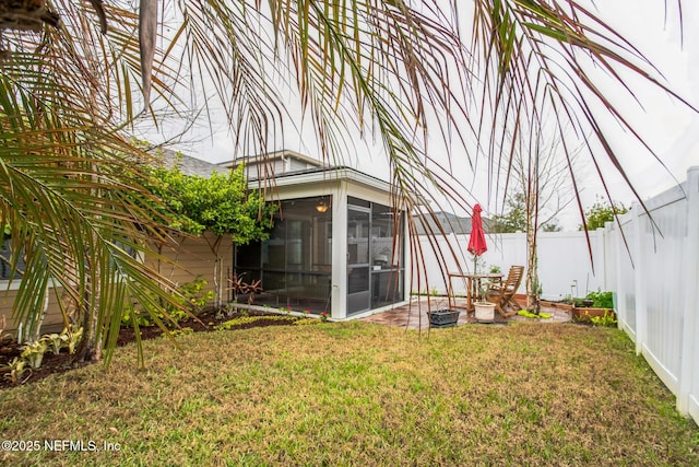 view of yard featuring a fenced backyard and a sunroom