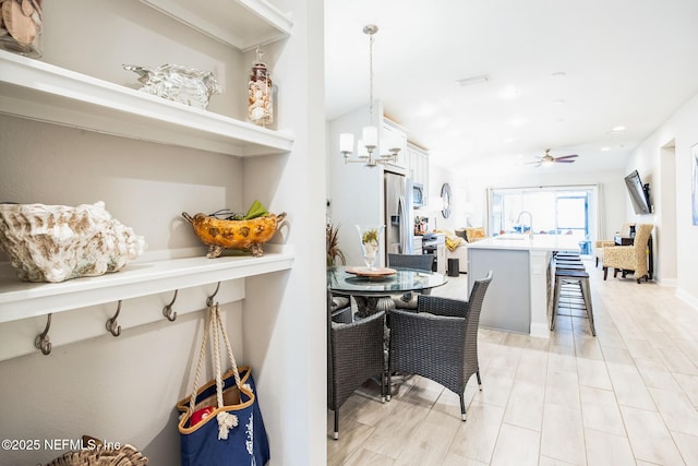 kitchen featuring white cabinets, appliances with stainless steel finishes, a breakfast bar area, light countertops, and pendant lighting