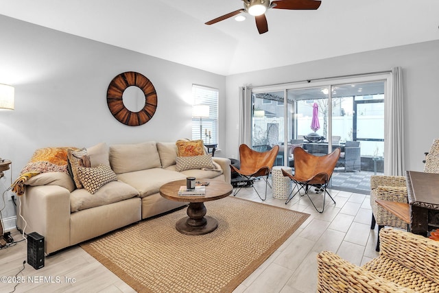 living area featuring light wood-style floors, ceiling fan, and vaulted ceiling