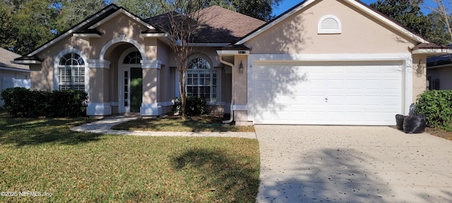 view of front of property featuring a garage, concrete driveway, roof with shingles, stucco siding, and a front yard