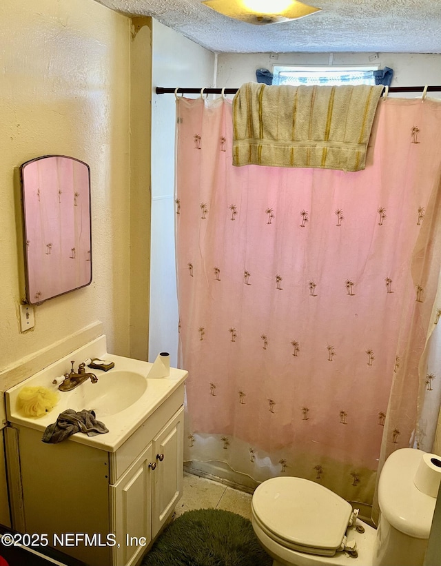 full bathroom with vanity, toilet, and a textured ceiling