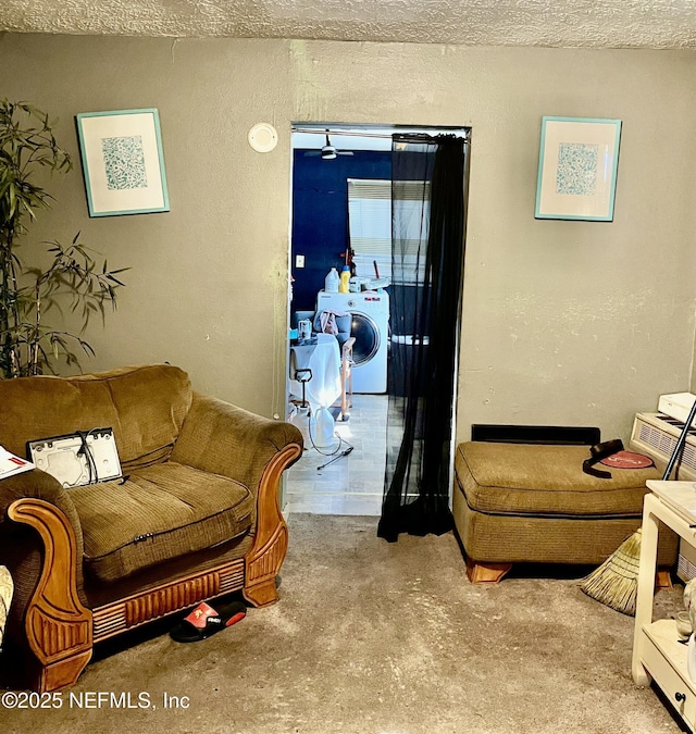 living room with washer / clothes dryer and a textured wall