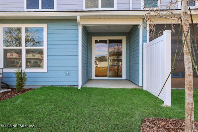 entrance to property featuring a lawn