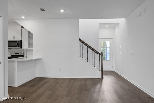 kitchen featuring visible vents, dark wood-type flooring, stainless steel appliances, light countertops, and white cabinetry