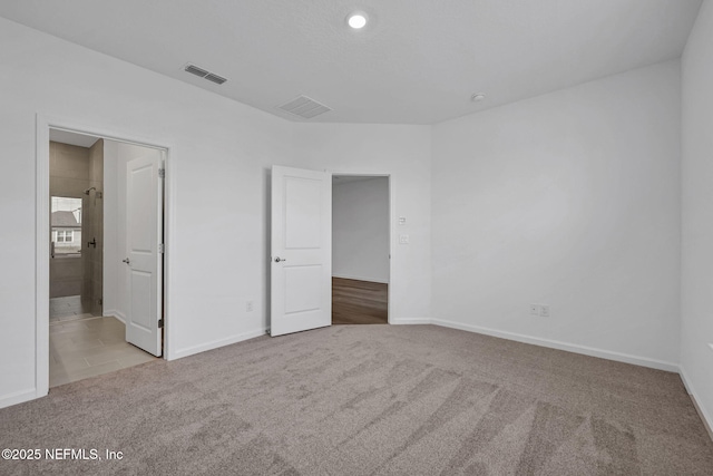 unfurnished bedroom with baseboards, visible vents, and light colored carpet