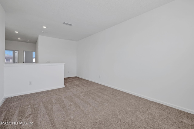 carpeted spare room with visible vents, baseboards, and recessed lighting