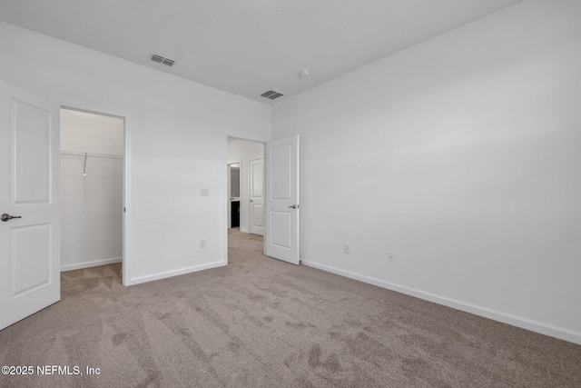 unfurnished bedroom with light carpet, baseboards, and visible vents