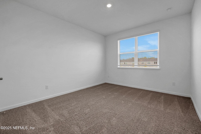 empty room featuring baseboards and carpet flooring