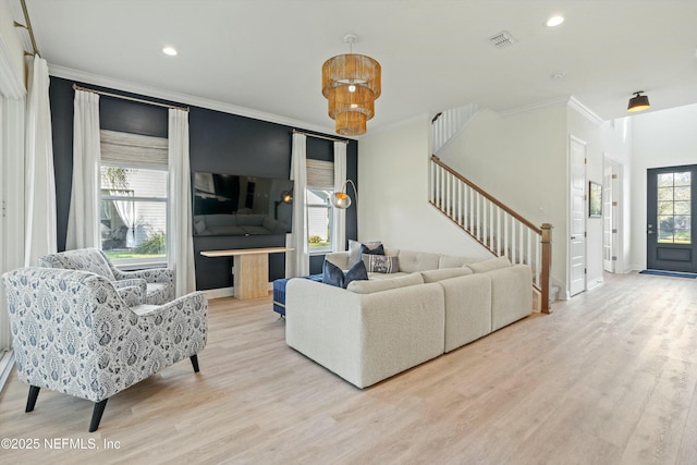 living room with visible vents, crown molding, stairway, and wood finished floors