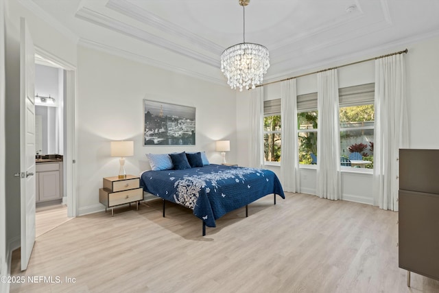 bedroom featuring crown molding, a raised ceiling, ensuite bathroom, light wood-type flooring, and baseboards