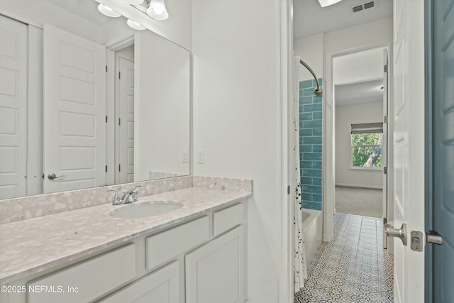 bathroom featuring shower / bath combination, visible vents, vanity, baseboards, and tile patterned floors