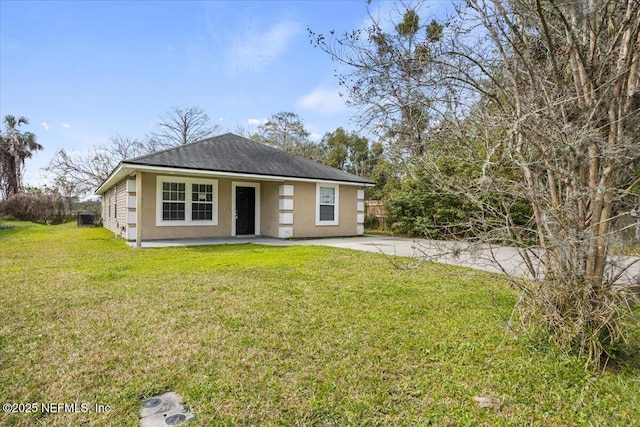 view of front of house featuring a front lawn, roof with shingles, and stucco siding