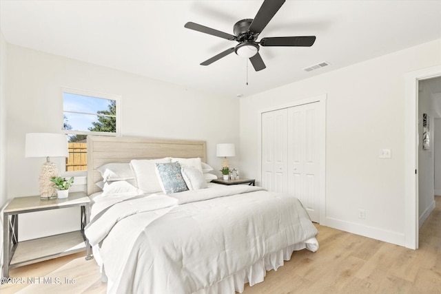 bedroom with baseboards, visible vents, ceiling fan, light wood-style floors, and a closet