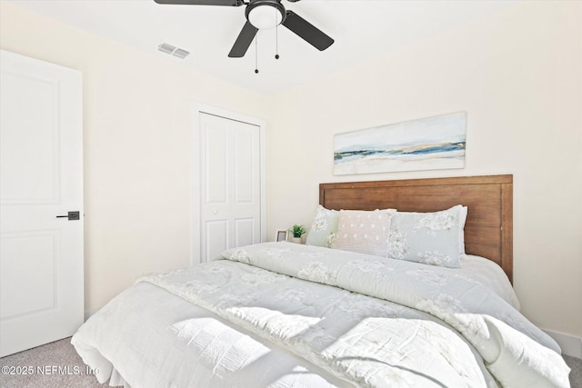 carpeted bedroom with ceiling fan, visible vents, and a closet