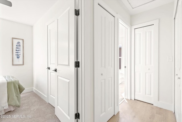 hall featuring light wood finished floors and baseboards