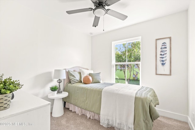 bedroom featuring baseboards, a ceiling fan, and light colored carpet