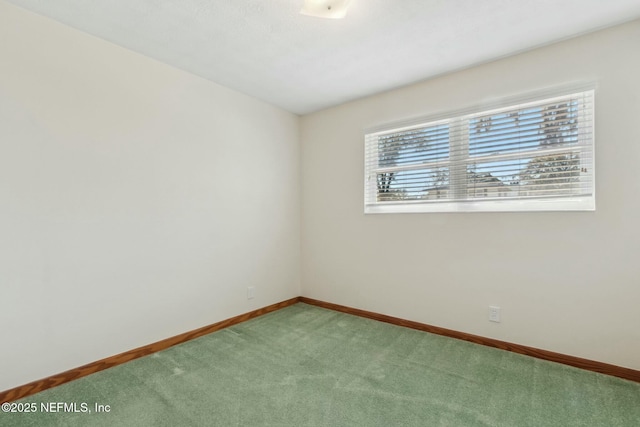 carpeted spare room with baseboards