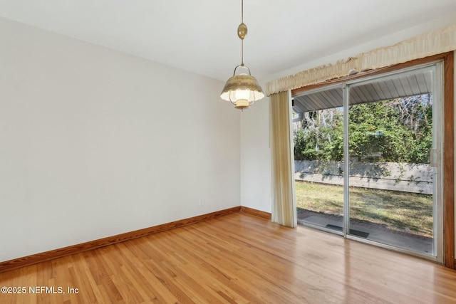 spare room featuring light wood-style flooring and baseboards