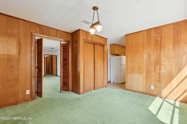 interior space with light carpet, visible vents, and wooden walls