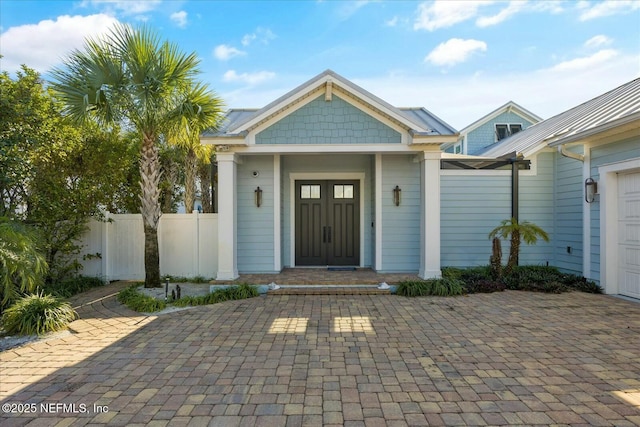 doorway to property with an attached garage and fence