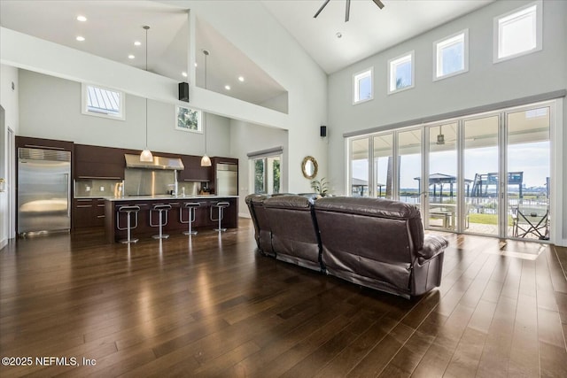 living area with dark wood-style flooring and ceiling fan