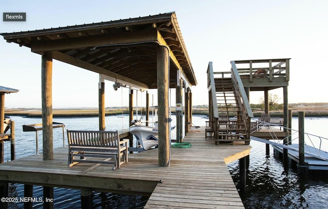 view of dock featuring a water view, boat lift, and stairs