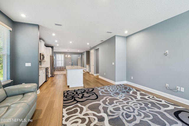 427 Ladyslipper Dr, Saint Johns, FL 32259 - interior space with open floor plan, a sink, light wood finished floors, visible vents, and white cabinets