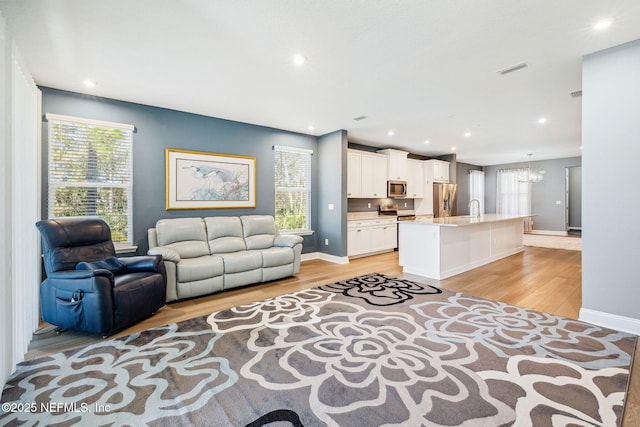 427 Ladyslipper Dr, Saint Johns, FL 32259 - living area with plenty of natural light, visible vents, light wood-style floors, and an inviting chandelier